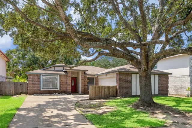 front view of a house with a yard and an trees