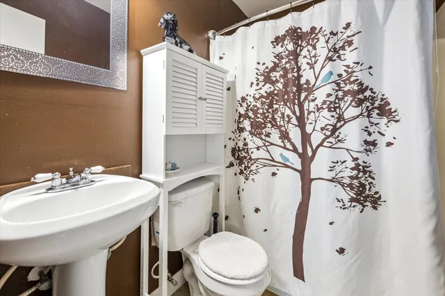 a bathroom with a sink toilet and a mirror