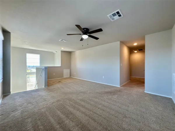 a view of a livingroom with a ceiling fan window and a kitchen