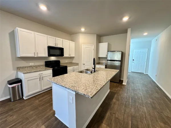 a kitchen with sink stove microwave and refrigerator