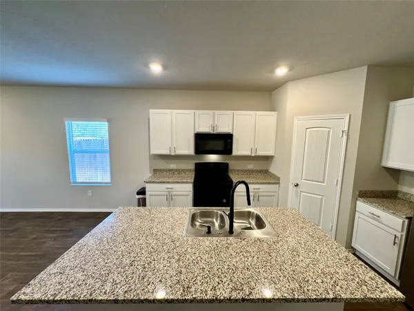 a kitchen with a stove a refrigerator and cabinets