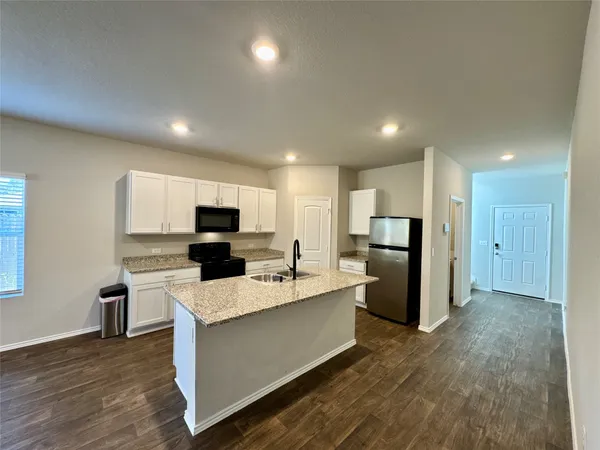a large kitchen with a large counter top appliances and cabinets