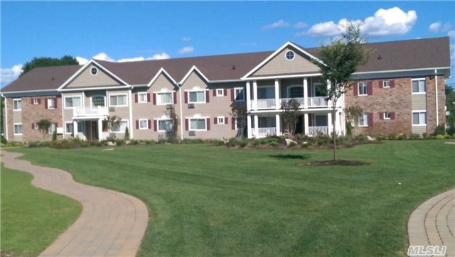 55 Mayfair Gardens, Unit 2F Commack, NY 11725 - Photo 1 of 1 a front view of a house with a garden