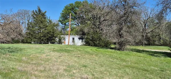 a view of a field of grass and trees