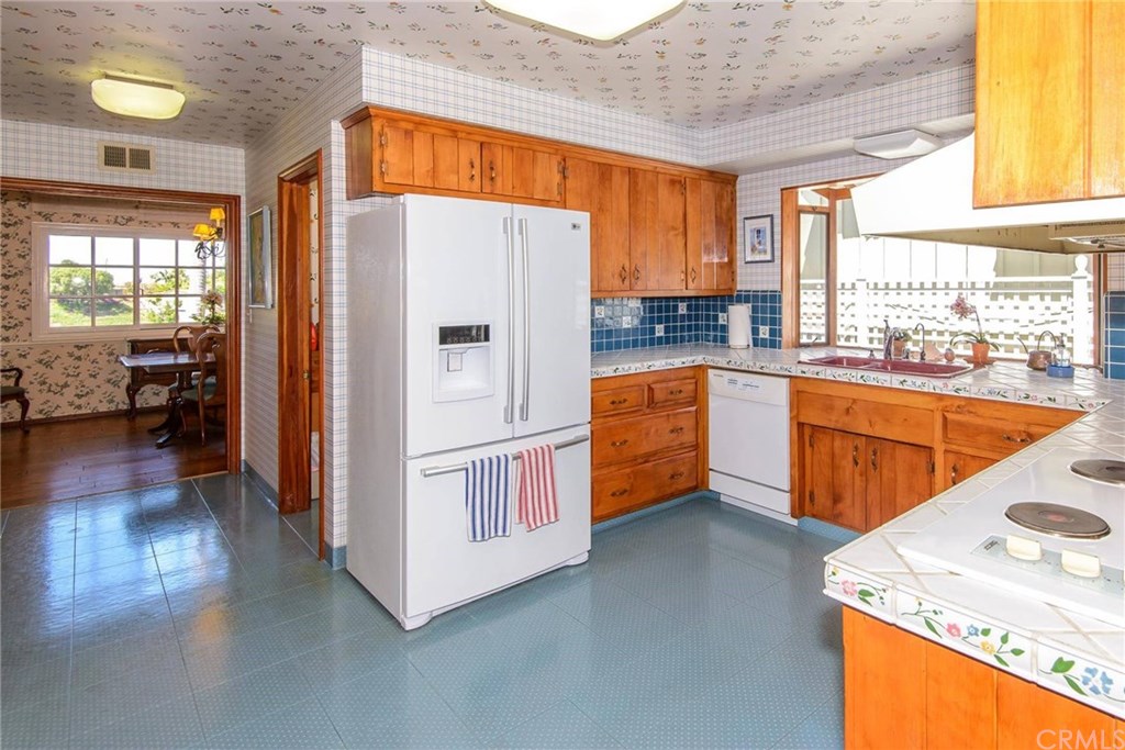 2721 Coral Ridge Road Rancho Palos Verdes, CA 90275 - Photo 3 of 24 a kitchen with stainless steel appliances granite countertop a refrigerator a sink dishwasher a stove and a dining table with wooden floor