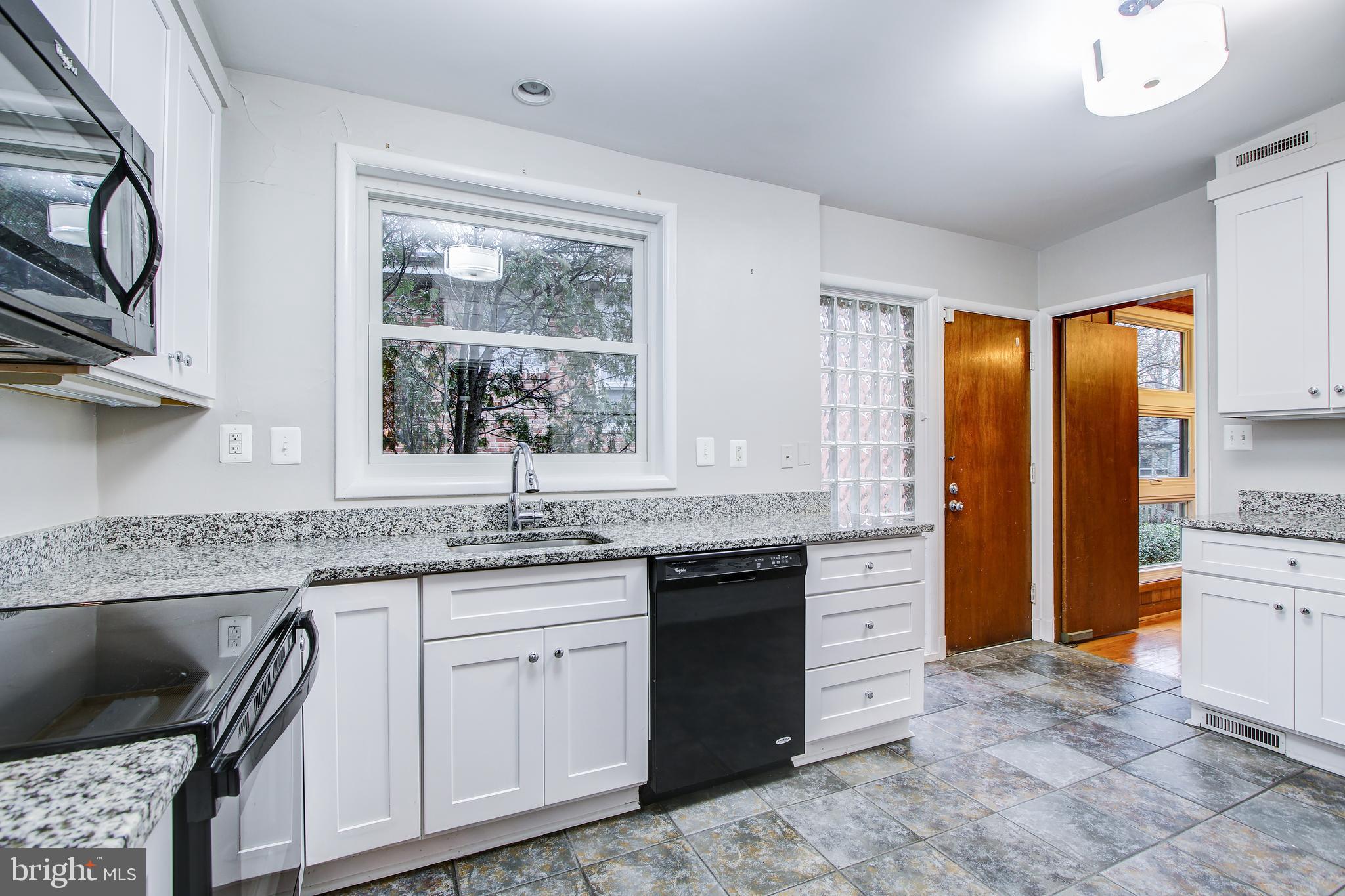 6006 28th Street Northwest Washington, DC 20015 - Photo 11 of 30 a kitchen with stainless steel appliances granite countertop a stove a sink and a refrigerator