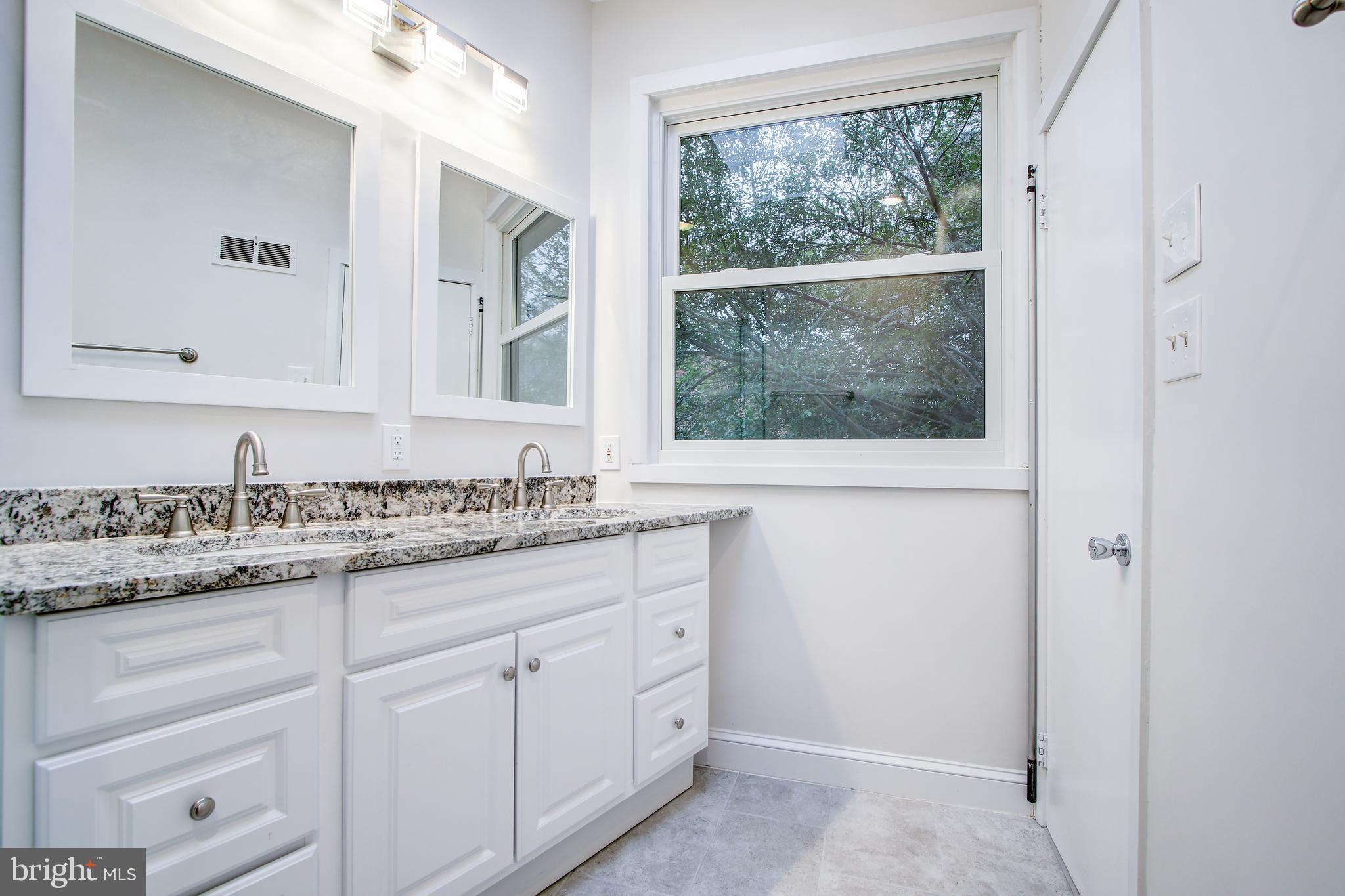 6006 28th Street Northwest Washington, DC 20015 - Photo 17 of 30 a bathroom with a granite countertop sink mirror and a window