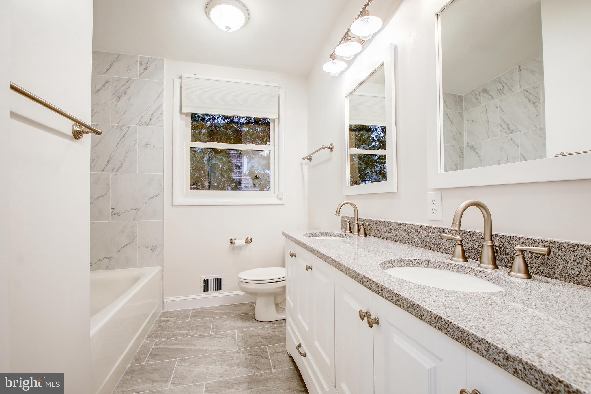 6006 28th Street Northwest Washington, DC 20015 - Photo 19 of 30 a bathroom with a granite countertop sink toilet and shower