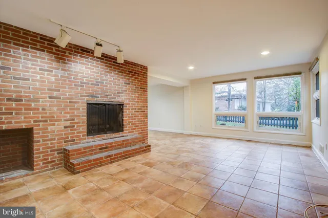 a view of empty room with fireplace and windows