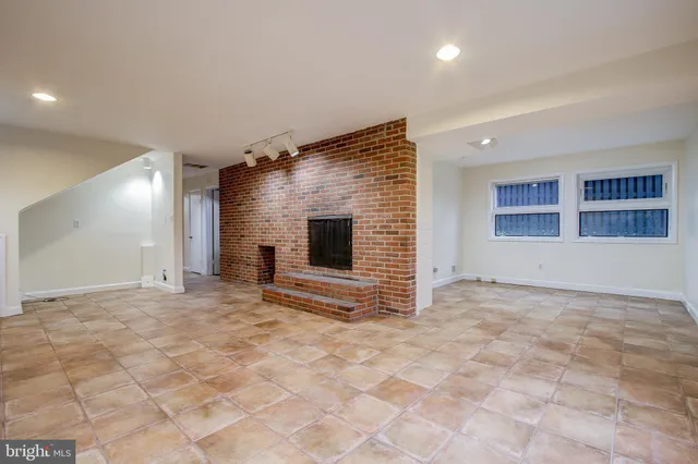 a view of an empty room with a fireplace and a window