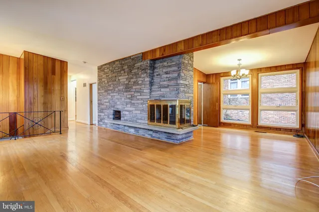a view of empty room with wooden floor and fireplace