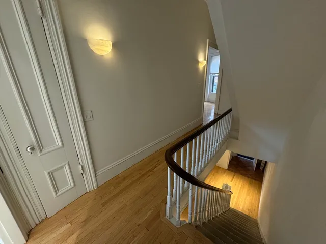 a view of a staircase with wooden floor and a window