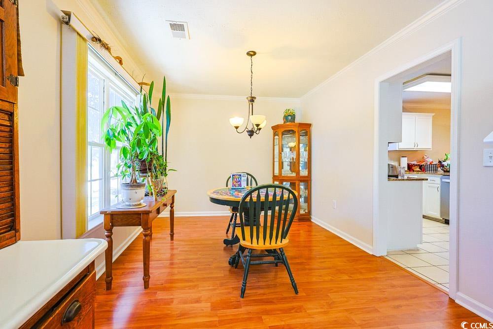 2033 Chadbury Lane Myrtle Beach, SC 29588 - Photo 13 of 39 Dining room with light wood-style floors, a chandelier, and crown molding