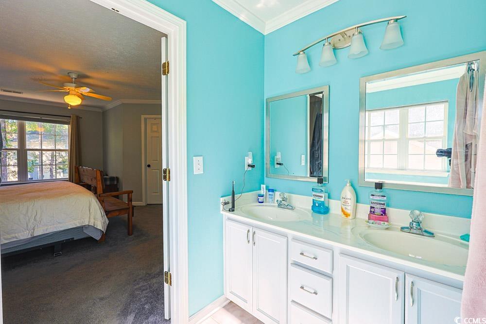 2033 Chadbury Lane Myrtle Beach, SC 29588 - Photo 17 of 39 Bathroom featuring ornamental molding, double vanity, light colored carpet, connected bathroom, and ceiling fan
