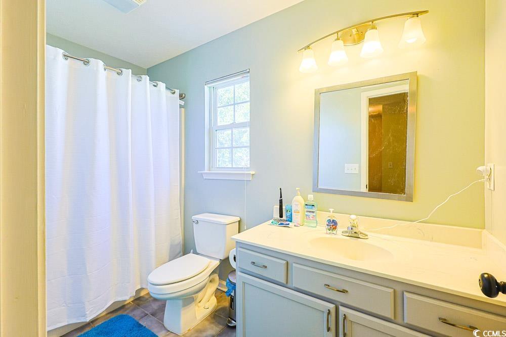 2033 Chadbury Lane Myrtle Beach, SC 29588 - Photo 28 of 39 Full bathroom featuring curtained shower, vanity, and dark tile patterned flooring