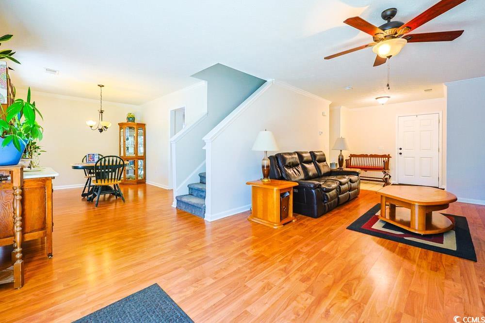 2033 Chadbury Lane Myrtle Beach, SC 29588 - Photo 3 of 39 Living area featuring stairway, ornamental molding, light wood-style flooring, a chandelier, and ceiling fan