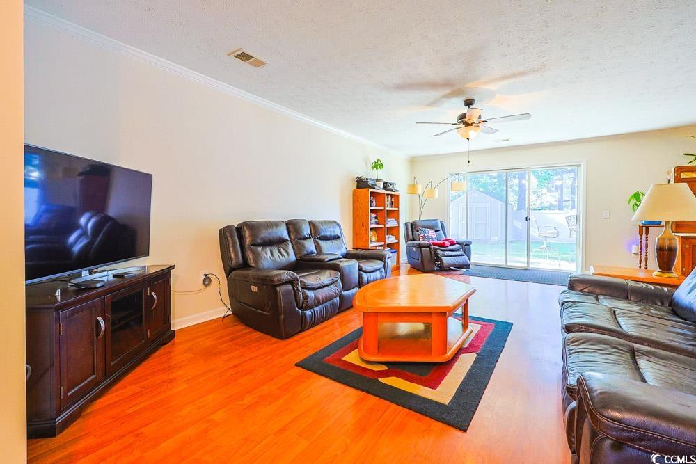 2033 Chadbury Lane Myrtle Beach, SC 29588 - Photo 4 of 39 Living area featuring light wood-type flooring, a textured ceiling, ornamental molding, and ceiling fan
