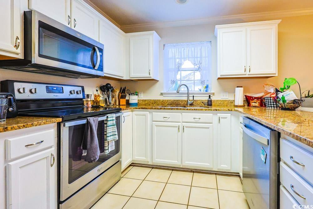 2033 Chadbury Lane Myrtle Beach, SC 29588 - Photo 8 of 39 Kitchen with appliances with stainless steel finishes, white cabinets, and ornamental molding