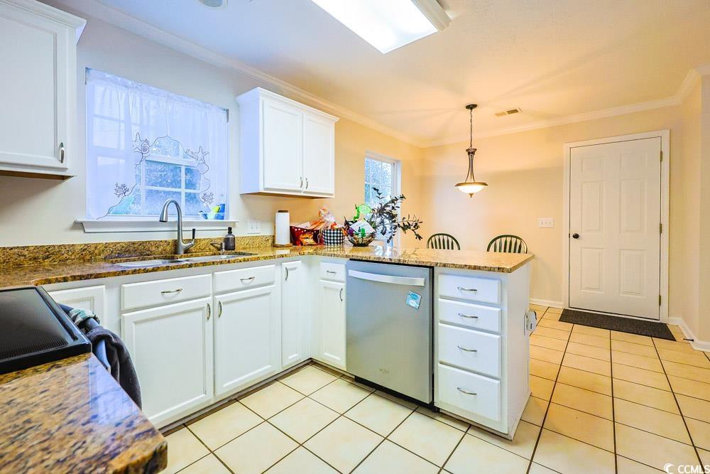 2033 Chadbury Lane Myrtle Beach, SC 29588 - Photo 9 of 39 Kitchen with a peninsula, crown molding, white cabinetry, dishwasher, and light tile patterned floors