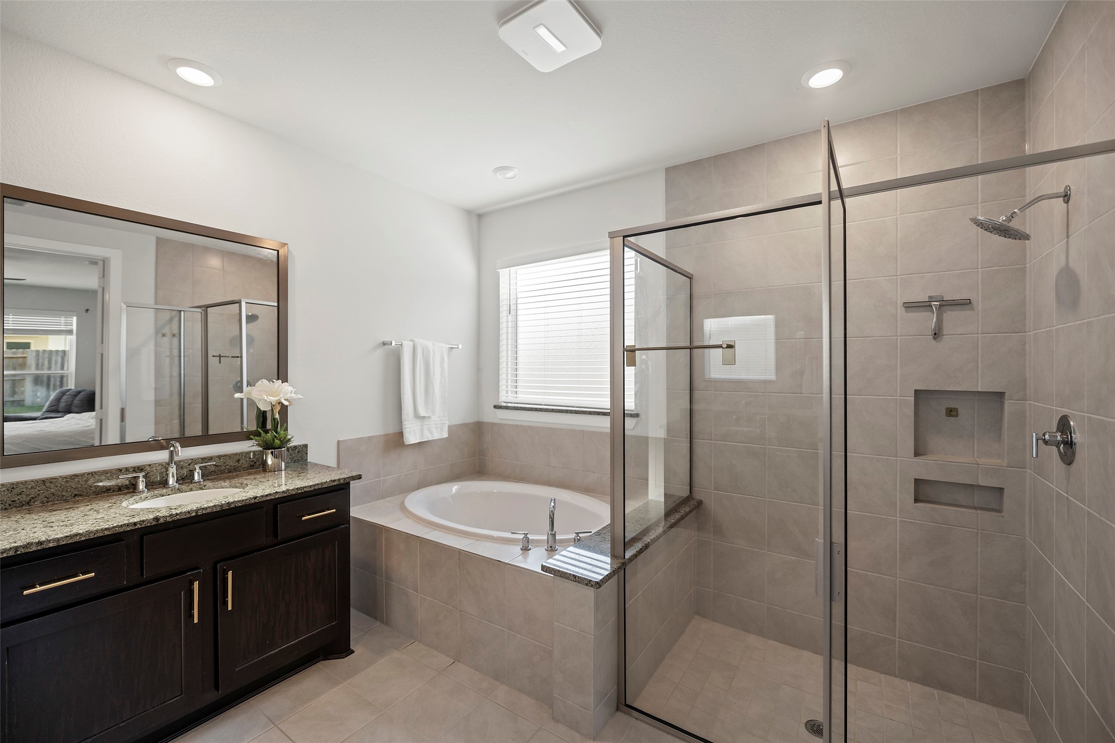 4802 Pecos Ridge Lane Sugar Land, TX 77479 - Photo 18 of 32 a bathroom with a granite countertop sink mirror bathtub and shower