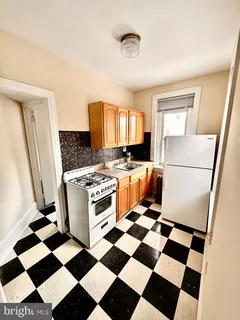 a kitchen with a checkered floor and white cabinets