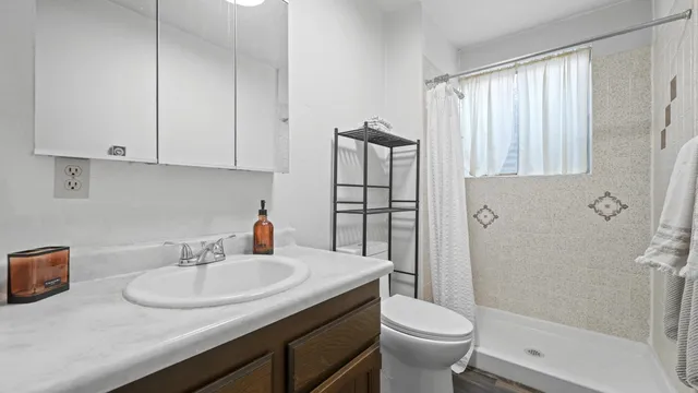 a bathroom with a granite countertop sink toilet and shower