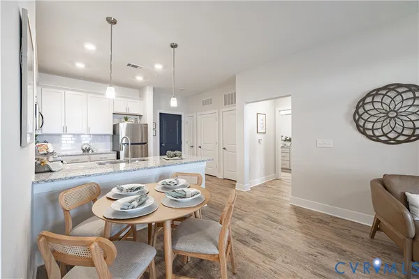 a kitchen with a dining table chairs stove refrigerator and cabinets