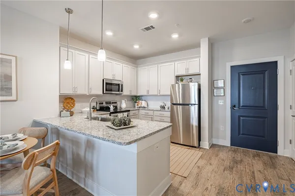 a kitchen with refrigerator cabinets and wooden floor