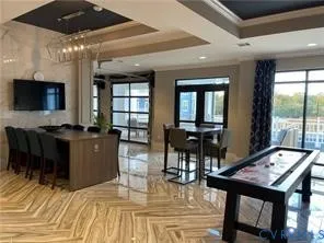 a living room with furniture a flat screen tv and a floor to ceiling window