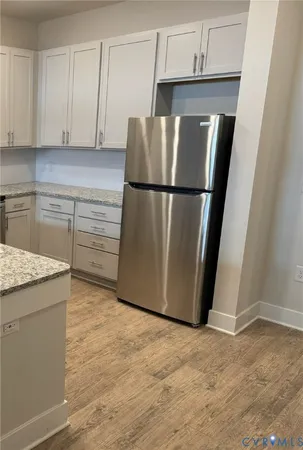 a metallic refrigerator freezer sitting in a kitchen
