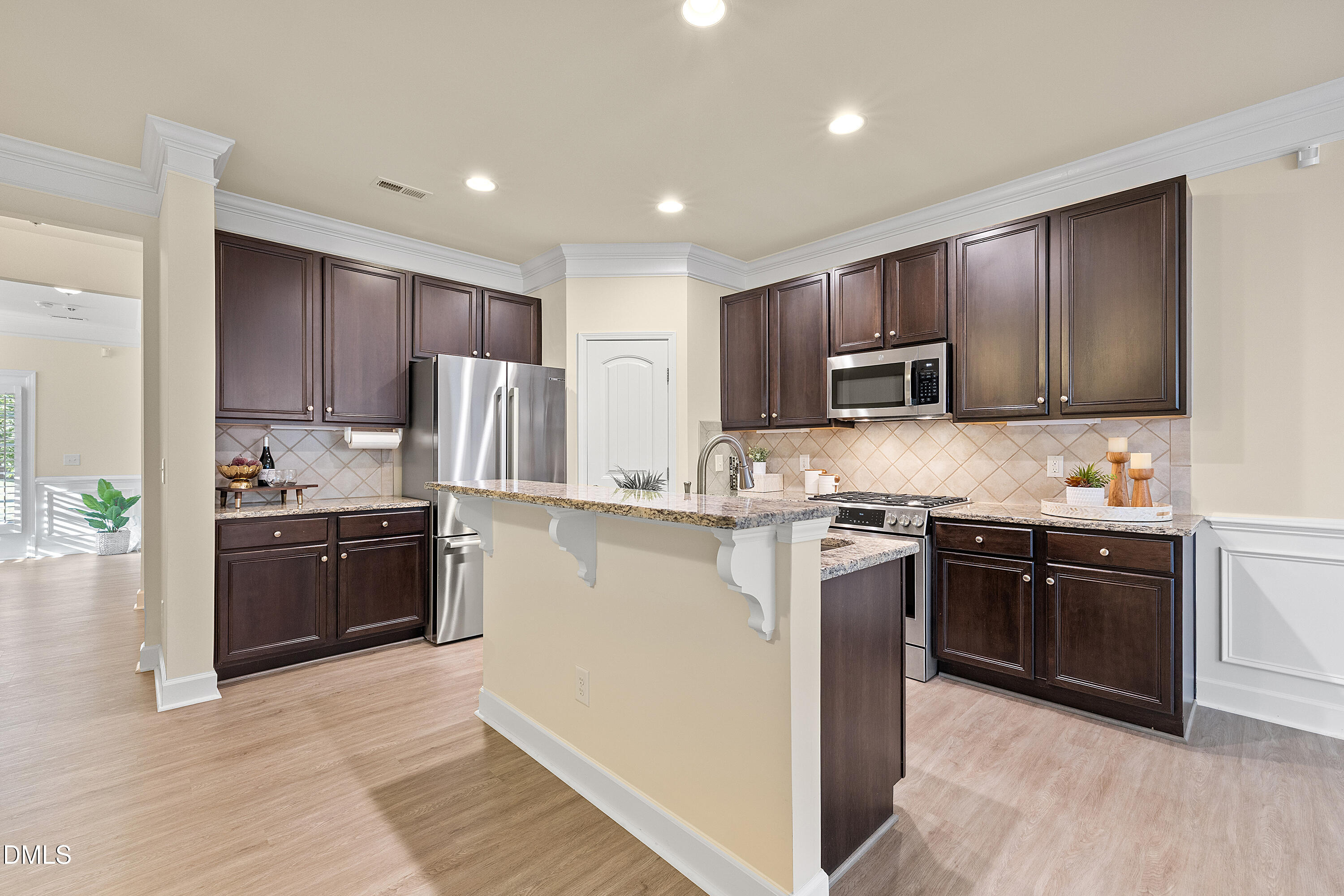 2063 Weston Green Loop Cary, NC 27513 - Photo 2 of 40 a kitchen with kitchen island granite countertop wooden cabinets stainless steel appliances and a granite counter tops