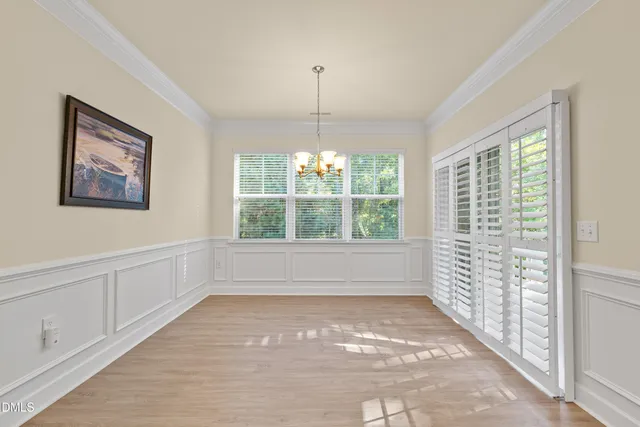 a view of an empty room with wooden floor fireplace and a window
