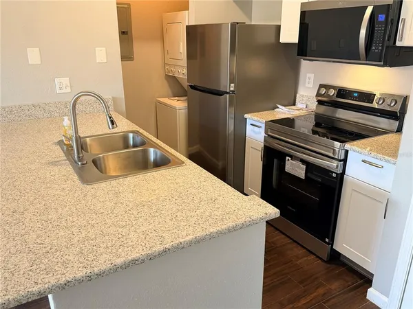 a kitchen with kitchen island a counter top space and stainless steel appliances