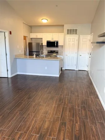 a view of kitchen with granite countertop window and stainless steel appliances