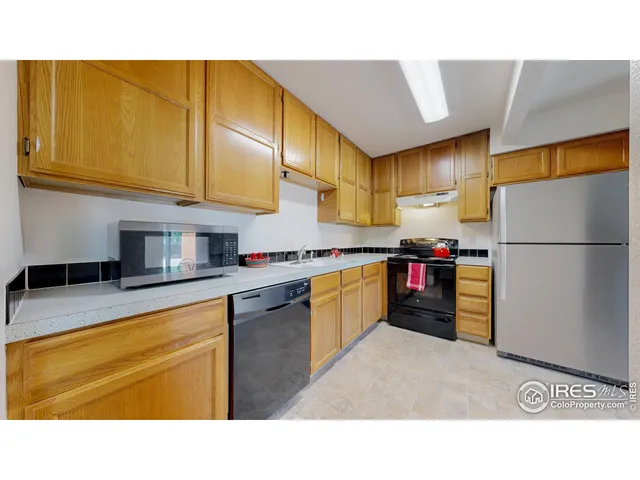 a kitchen with stainless steel appliances granite countertop a refrigerator a stove and a sink