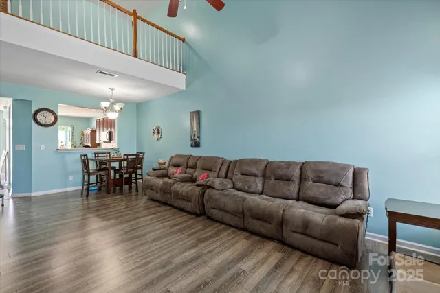 a living room with furniture and a dining table with wooden floor