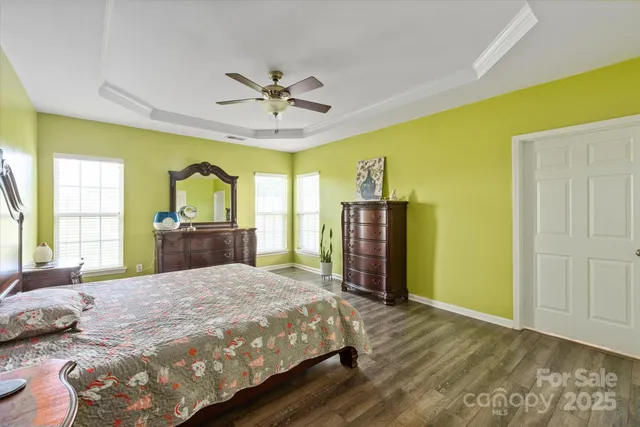 a bed sitting in a spacious bedroom next to a window