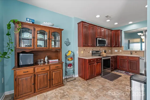 a kitchen with stainless steel appliances kitchen island granite countertop a stove sink and cabinets