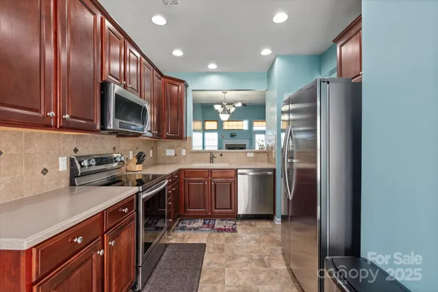 a kitchen with stainless steel appliances granite countertop a refrigerator stove and sink