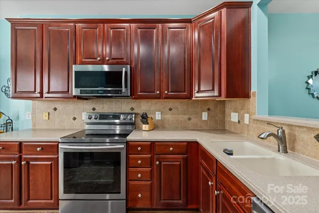 a kitchen with granite countertop a sink a stove and cabinets