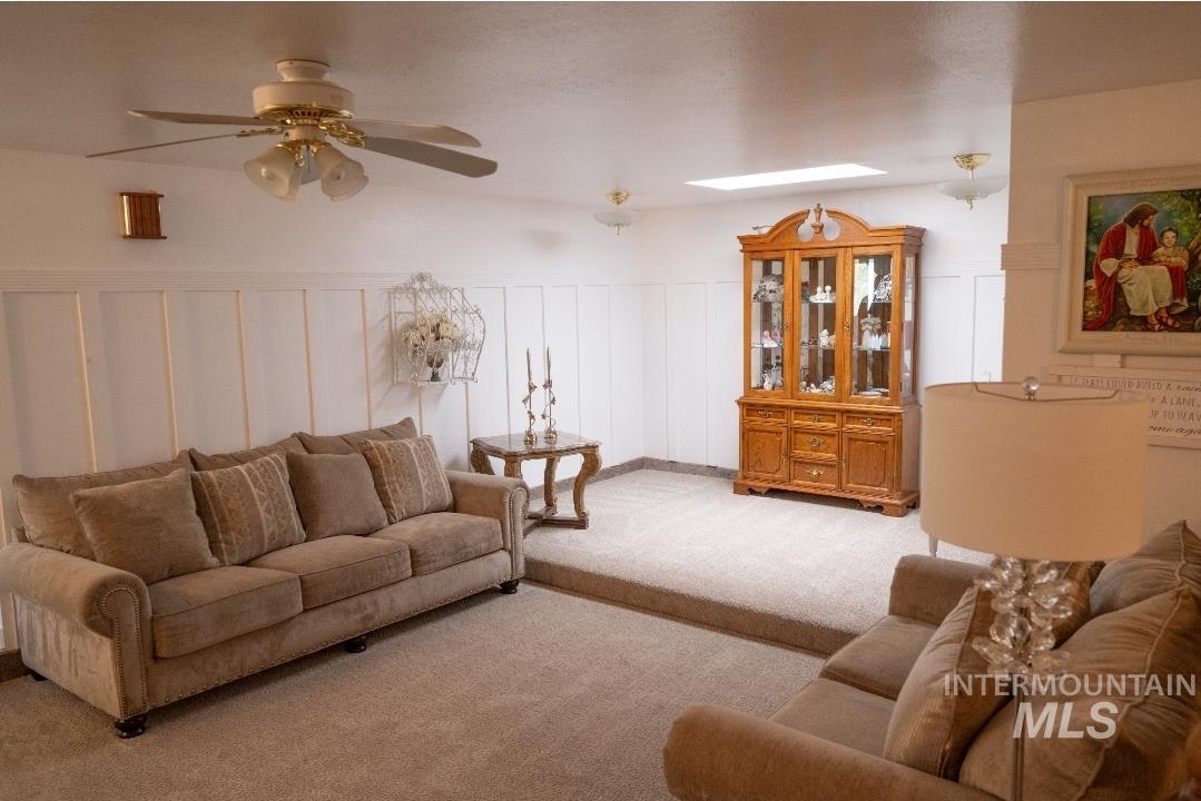 650 West 800 S Road Burley, ID 83318 - Photo 10 of 31 Living area featuring a decorative wall, carpet floors, a ceiling fan, and wainscoting