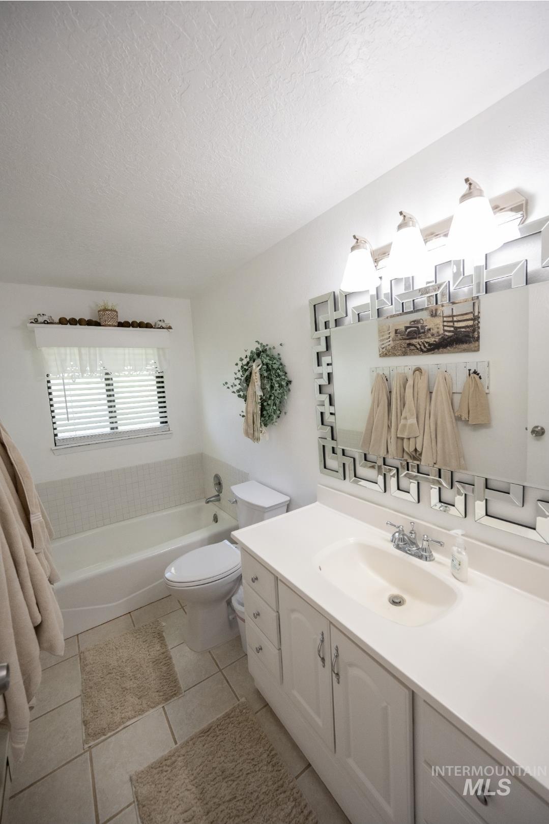 650 West 800 S Road Burley, ID 83318 - Photo 13 of 31 Bathroom featuring vanity, a textured ceiling, and light tile patterned floors