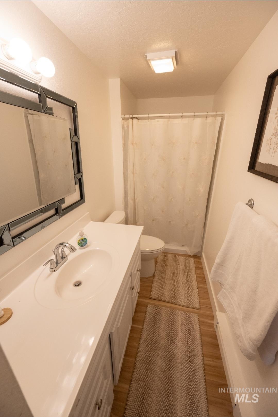 650 West 800 S Road Burley, ID 83318 - Photo 14 of 31 Bathroom with a shower with shower curtain, vanity, light wood-style floors, and a textured ceiling