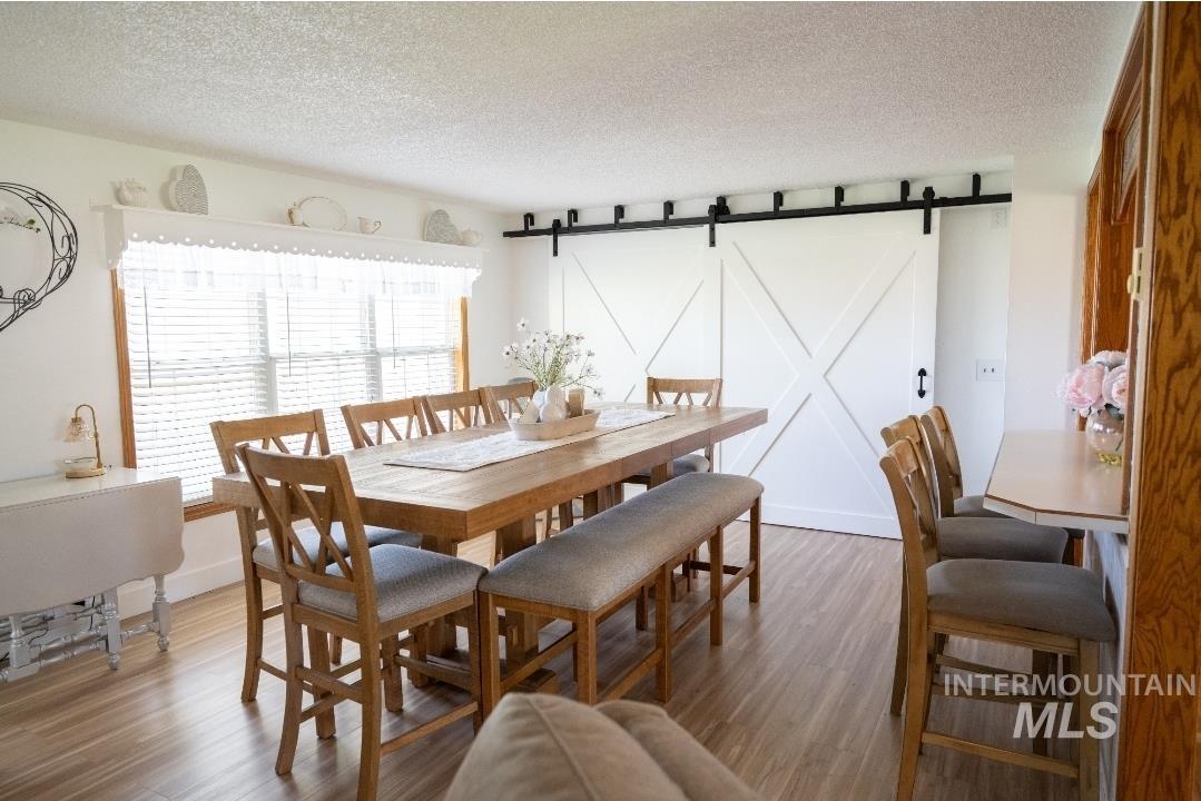 650 West 800 S Road Burley, ID 83318 - Photo 7 of 31 Dining space featuring a barn door, wood finished floors, and a textured ceiling