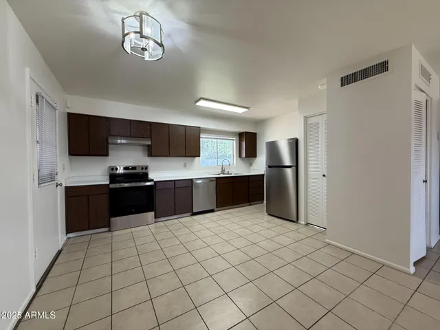 a large kitchen with a large counter top stainless steel appliances and cabinets