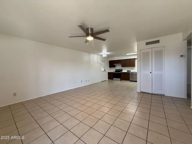 a view of an empty room and a ceiling fan