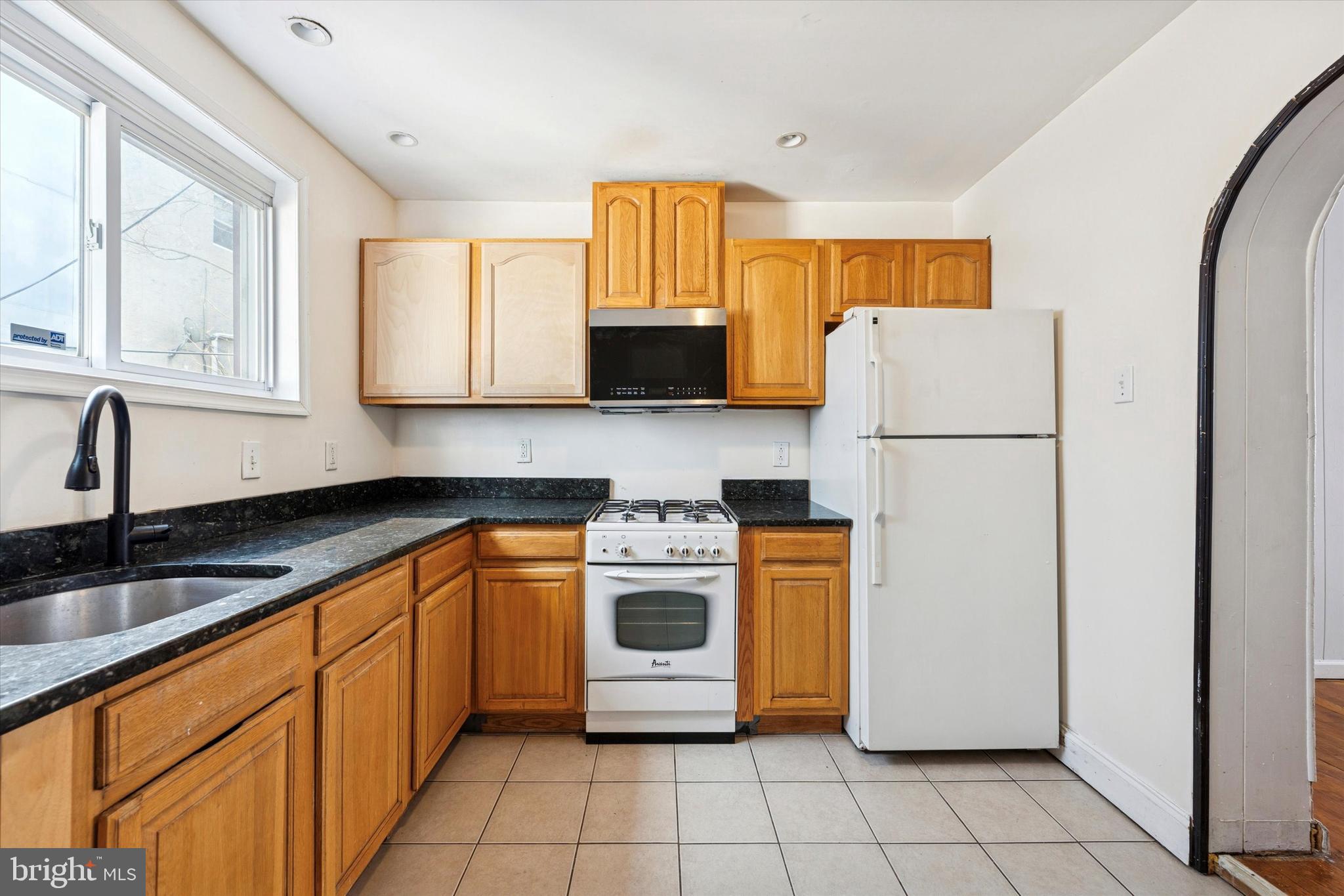 729 South Smedley Street Philadelphia, PA 19146 - Photo 10 of 25 a kitchen with a refrigerator sink and wooden cabinets