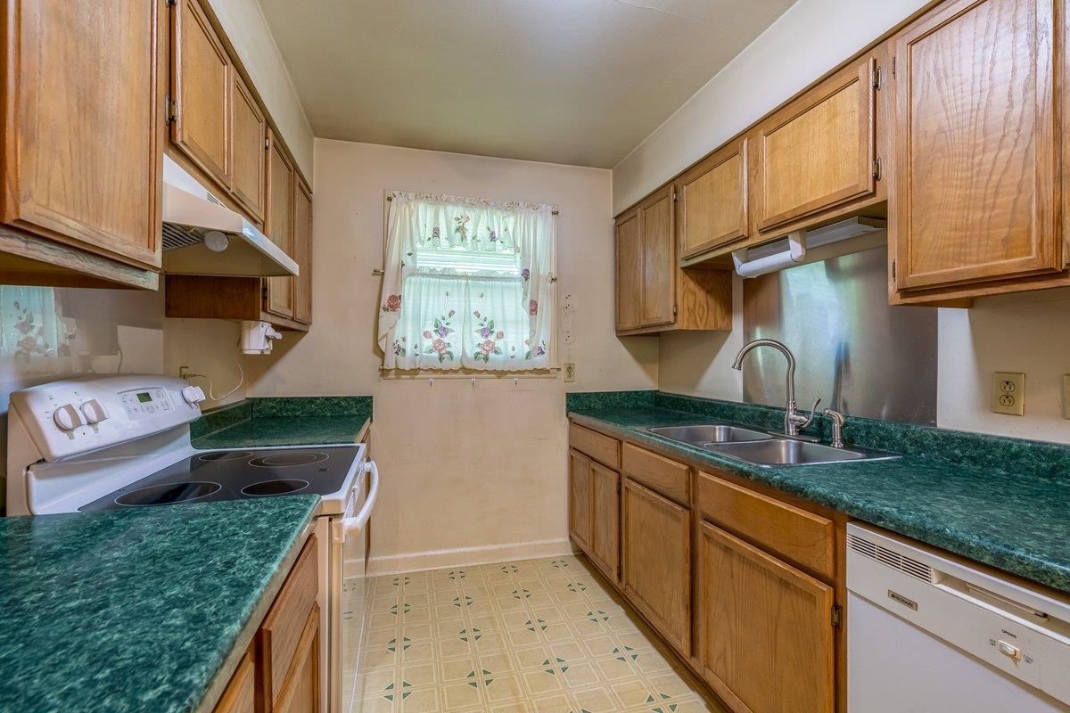 6237 Brunswick Road Arlington, TN 38002 - Photo 6 of 25 a kitchen with granite countertop a sink a stove and a wooden cabinets