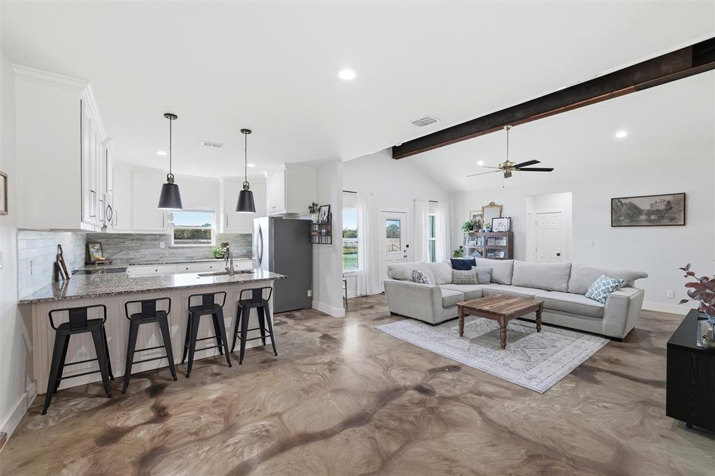 a living room with lots of furniture and kitchen view
