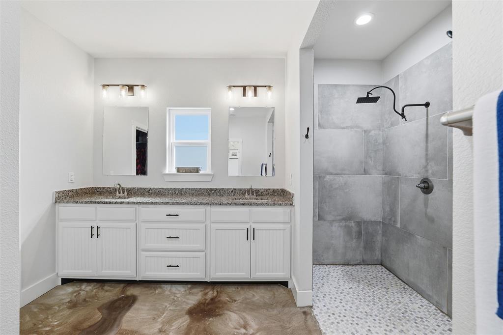 405 Advance Road Weatherford, TX 76088 - Photo 22 of 35 a bathroom with a granite countertop sink a mirror and shower